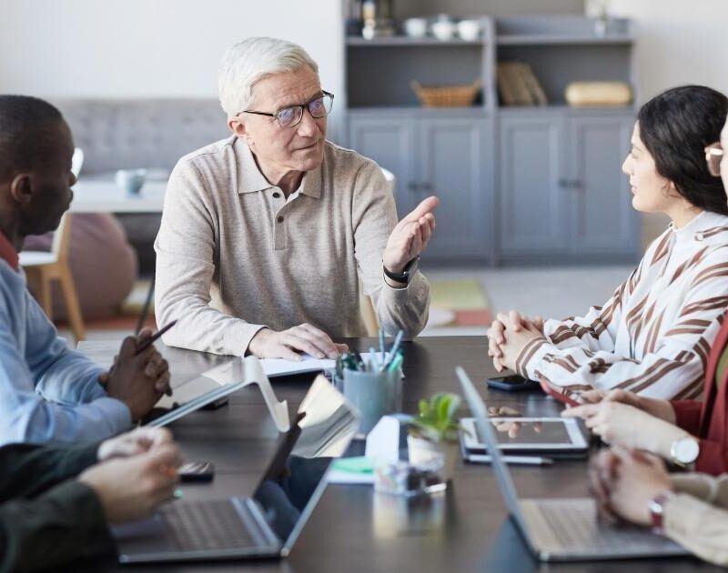 grupo de trabajadores de diferentes edades reunidos