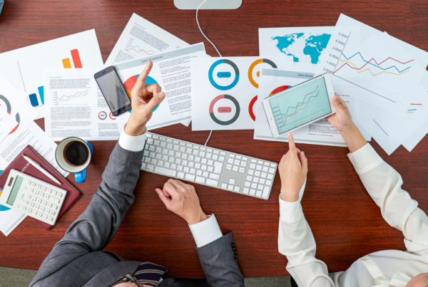 Personas corporativas en oficina con documentos de estadisticas sobre el escritorio